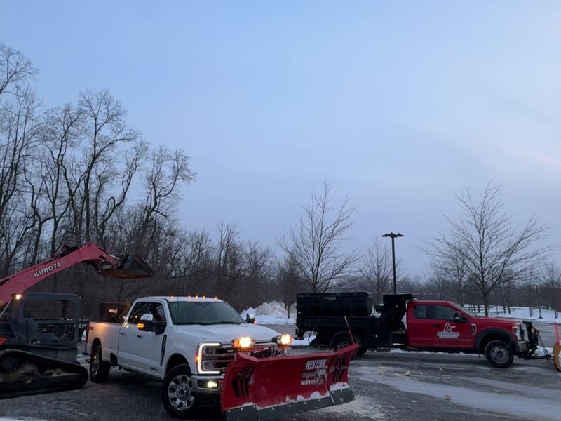 Aquilante Industries plow trucks, dump trailers and excavator staged before a snow event