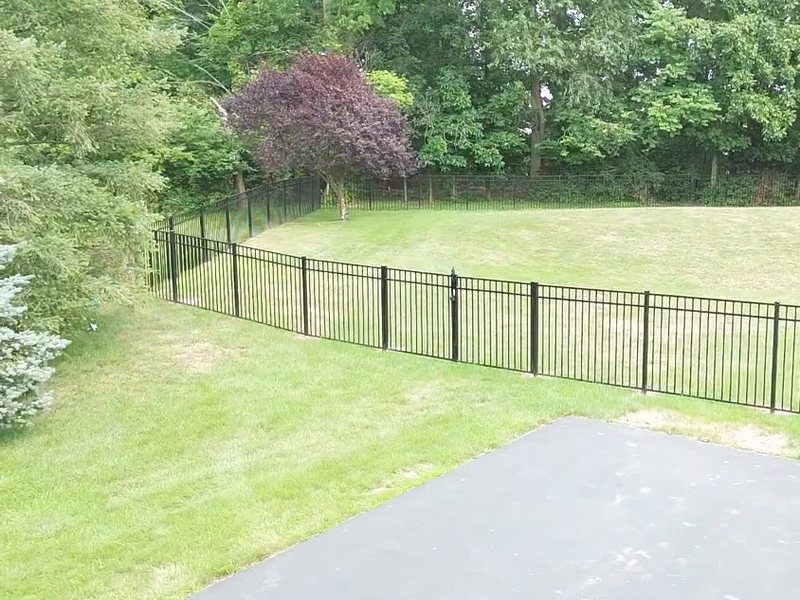Completed fence and gate installation at a property boundary